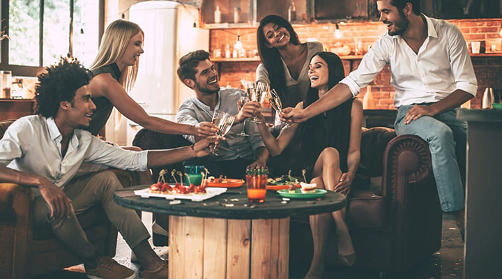 young professionals at a bar/restaurant toasting with champagne