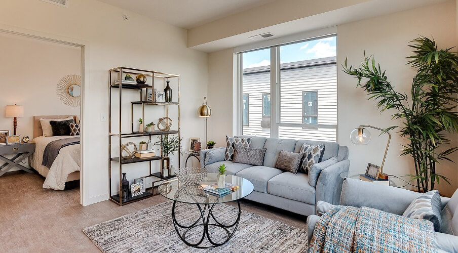 an apartment living room and visual of the bedroom through the door